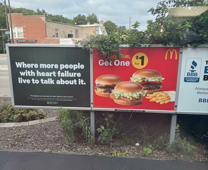Two adjacent ads with a confusing placement fail: heart failure awareness next to McDonald’s $1 burger deal on a roadside billboard.