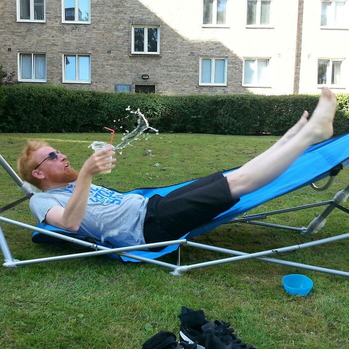 Man falling off hammock spilling drink perfectly timed photo capturing natural motion outdoors