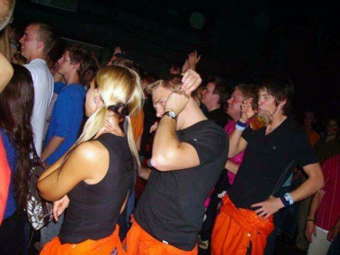 People at a crowded party captured in a perfectly timed photo showing synchronized movements and expressions.
