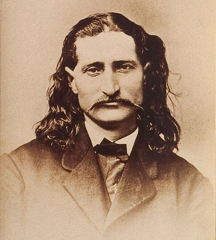 Vintage portrait of American folk hero Wild Bill Hickok with long hair and mustache in 19th century attire.