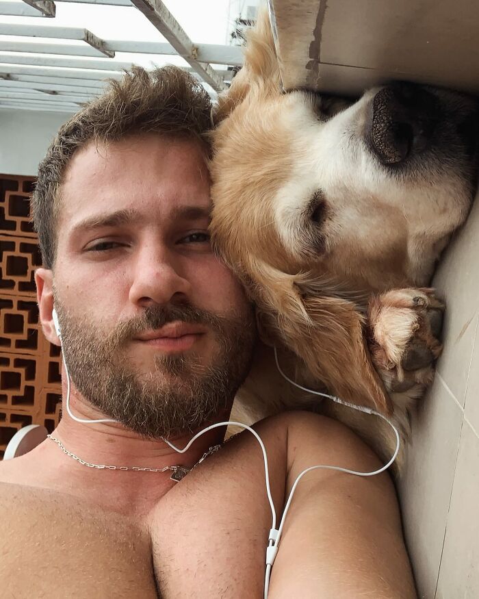 Man lying next to Theo the Golden Retriever, both resting closely together in a peaceful moment.