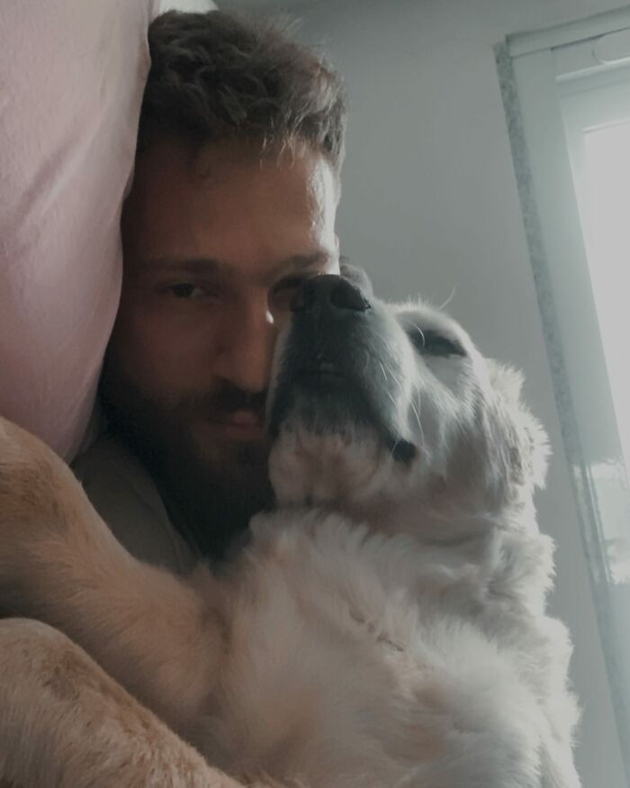 Man cuddling with Theo the golden retriever, reflecting a deep bond and touching many lives together.