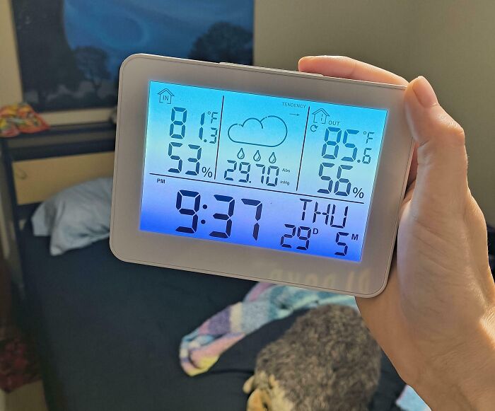 Digital thermometer showing indoor and outdoor temperature and humidity in a renter's room, highlighting landlord issues.