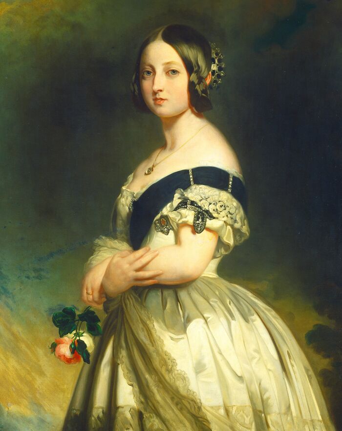 Victorian woman in elegant dress holding a rose, representing bizarre and creepy Victorian facts of the era.