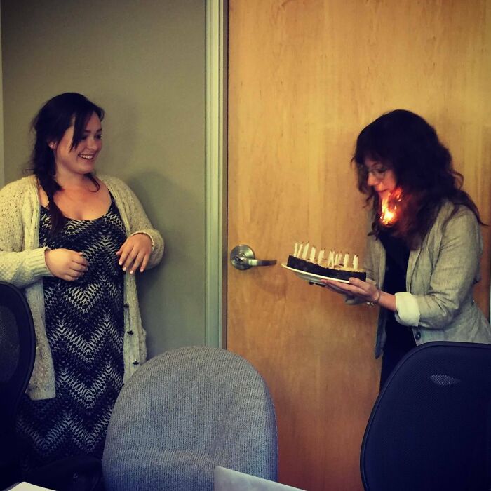 Woman appears to catch fire while holding birthday cake with lit candles, a perfectly timed photo better than any Photoshop.