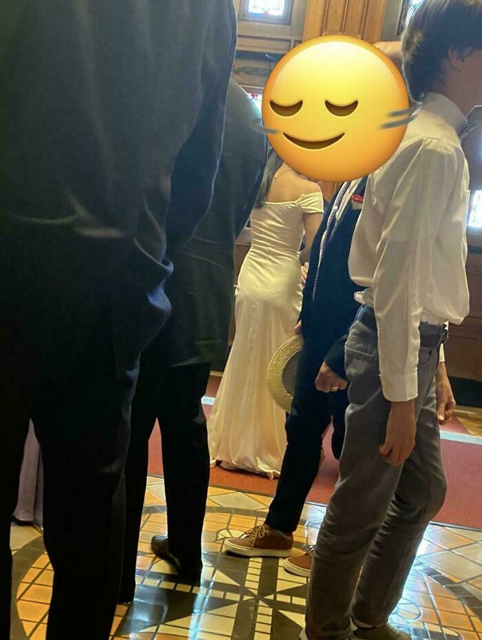 Wedding guests and bride, groom in formal attire with an emoji face, illustrating worst brides and grooms shaming moments.