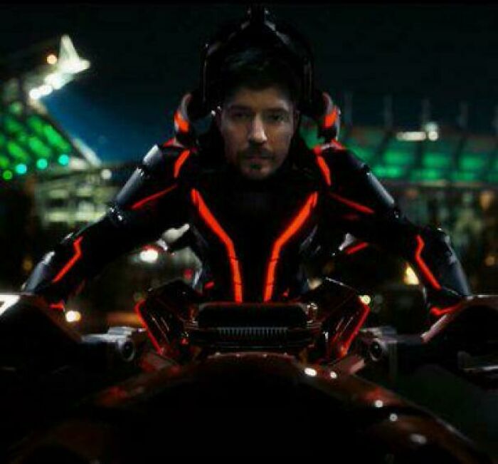 Man in futuristic glowing suit sitting in vehicle at night, featured in bad movie details group sharing confusing scenes.
