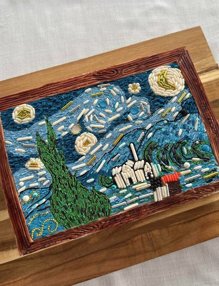 Baked goods designed to resemble Starry Night with detailed edible beads and icing on a wooden serving board.