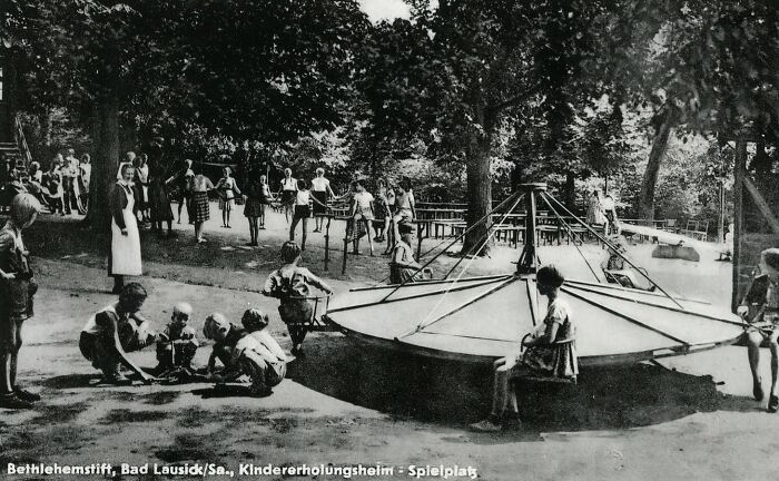 Historic photo of playground with children playing on old equipment, illustrating risks of being a kid back then.