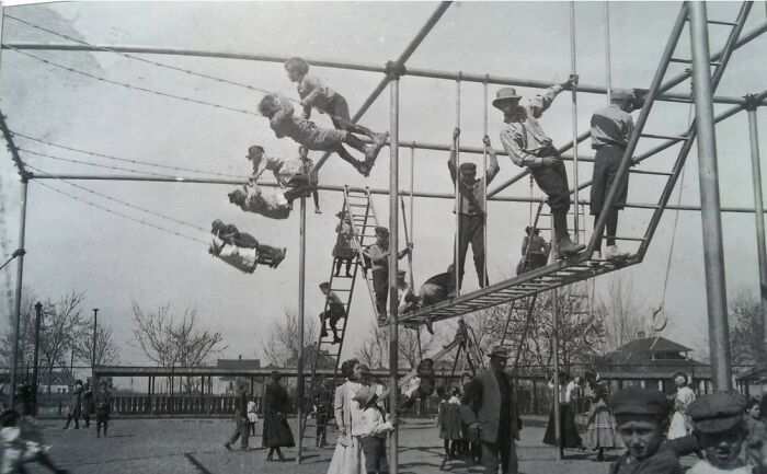 Historic playground photo showing risk-filled play equipment with kids swinging and climbing on metal structures.