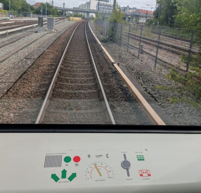 View of railway tracks from inside a Danish train, showcasing modern transit and infrastructure in Denmark.