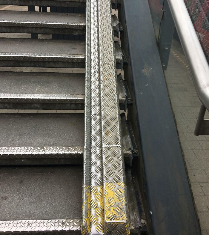 Metal staircase with textured steps and handrail, showcasing elements typical in a Danish prison cell design.