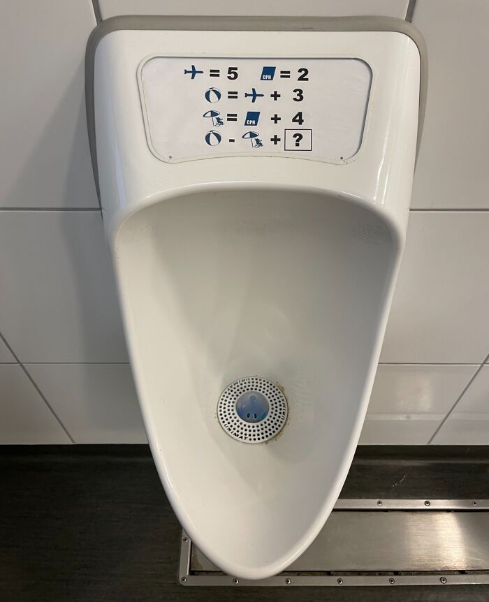 Urinal with a math puzzle above it, showcasing quirky design found in a Danish prison cell.