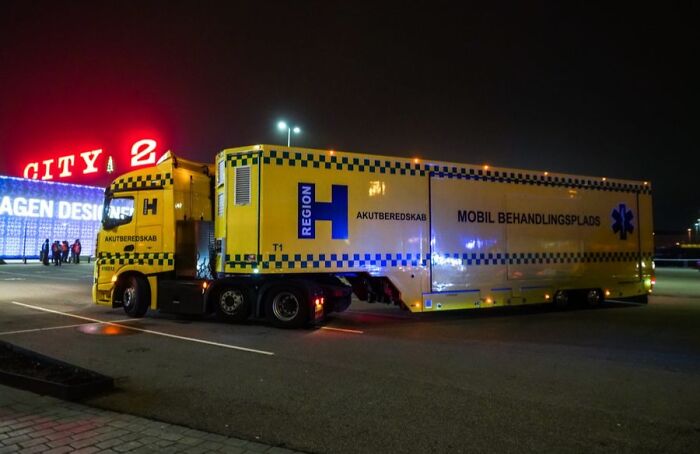 Yellow Danish emergency mobile treatment unit truck parked at night, showcasing Denmark’s advanced medical response system.