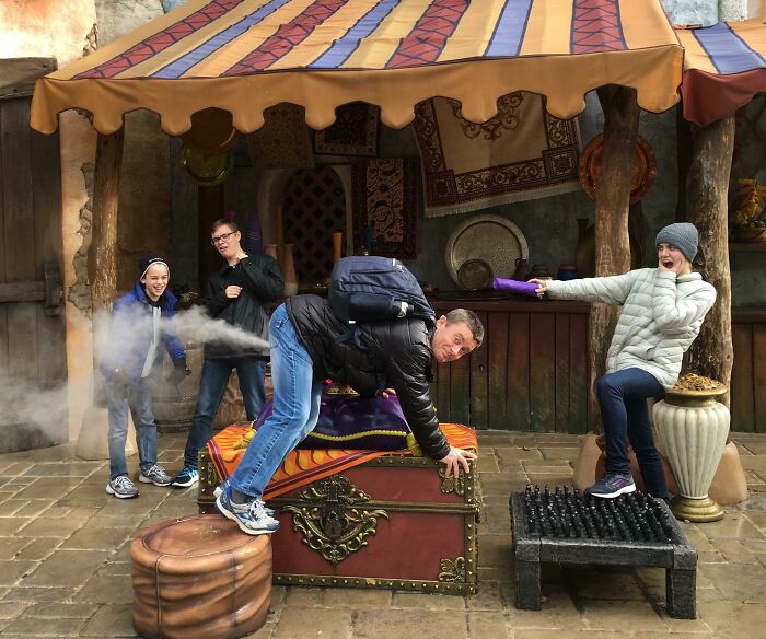 Group of people posing with amusement park props, capturing one of the best photos brought home from an amusement park trip