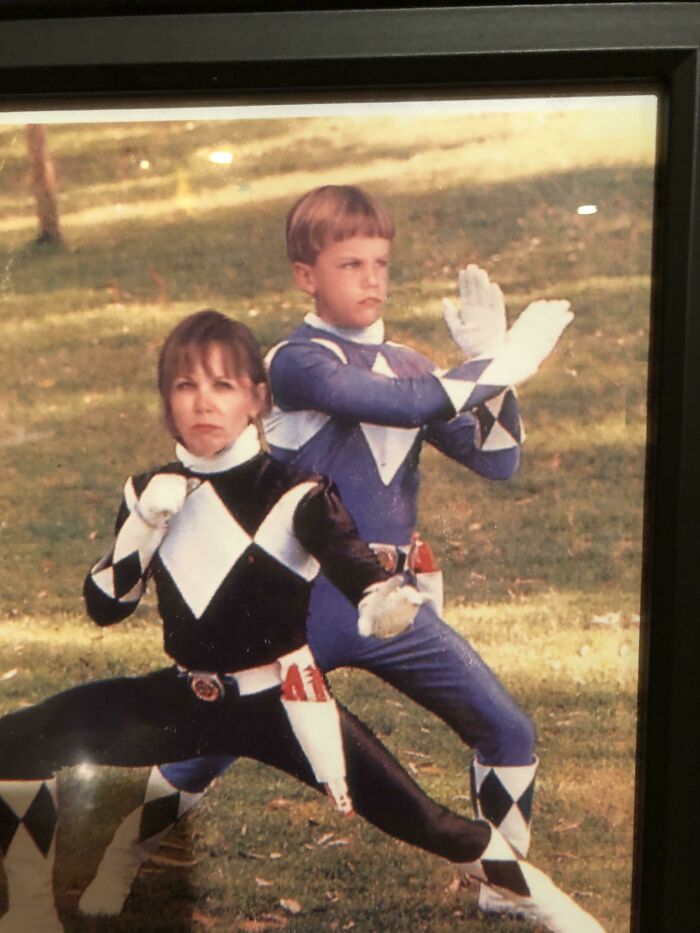 Two people dressed as Power Rangers in funny poses outdoors, showcasing the funniest parents ever in costumes.