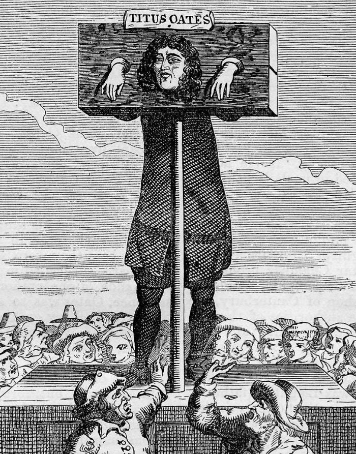 Medieval t*****e device showing a man restrained in a wooden pillory surrounded by a crowd in historical illustration.