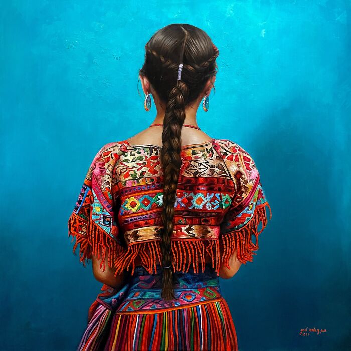 Woman in colorful traditional clothing with long braided hair, representing women’s strength and beauty across cultures.