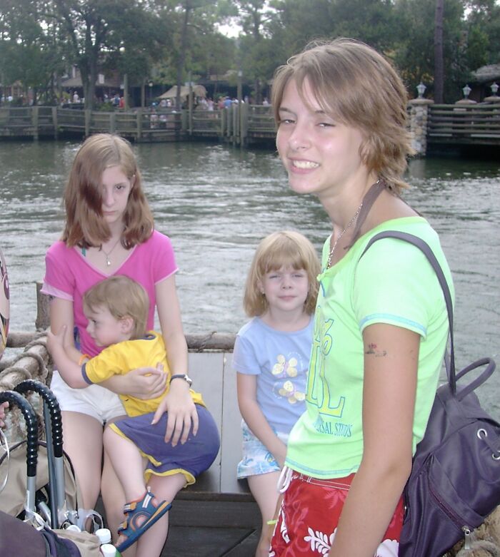 Family at an amusement park water ride with kids and a woman smiling, capturing the fun memories from the trip.
