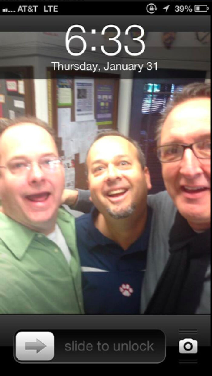 Three teachers smiling for a funny selfie in a school hallway, showcasing their sense of humor and cheerful attitudes.