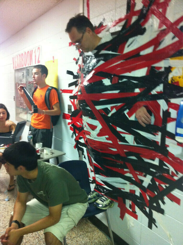 Teacher taped to the wall in hallway as a funny prank by students, showcasing humorous teachers in a school setting.
