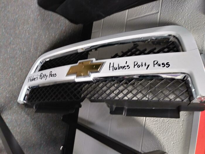 Chevrolet car front bumper with humorously written text Hulme’s Potty Pass, showcasing funny teachers' sense of humor.