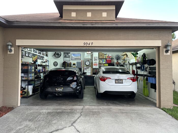 Two cars parked inside a neatly organized garage, highlighting luxury and complaints from rich people traveling.