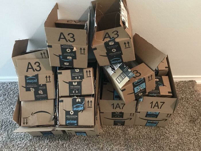 Stack of crumpled Amazon Prime boxes on carpet, illustrating complaints from rich people no longer enjoying traveling to the Bahamas.