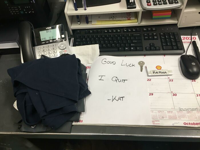 Desk with a resignation note saying I quit, work clothes folded, and office supplies showing why people hate their boss.