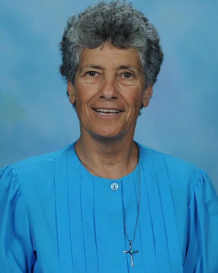 Older woman with short gray hair wearing a blue blouse and cross necklace, featured in chilling messages before going missing.