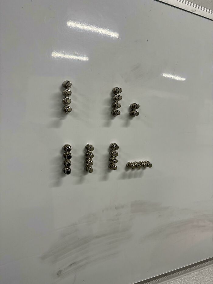 Magnets arranged in unusual patterns on a whiteboard, one of the curious things people discovered with no idea what it was.