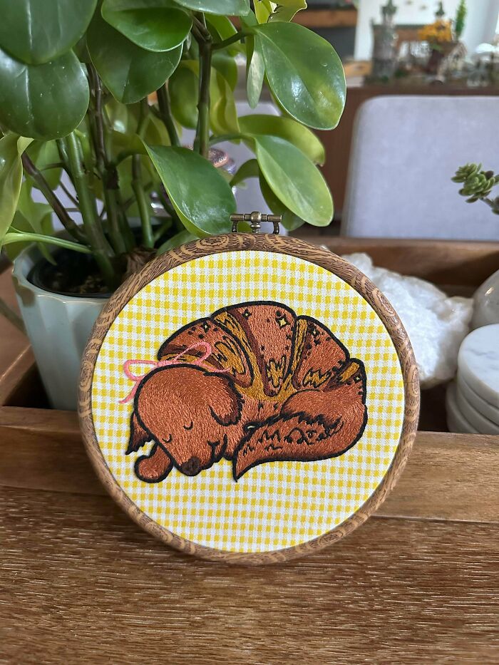 Adorable sleeping dog embroidery creation on a yellow checkered fabric, a charming piece for new hobby enthusiasts.