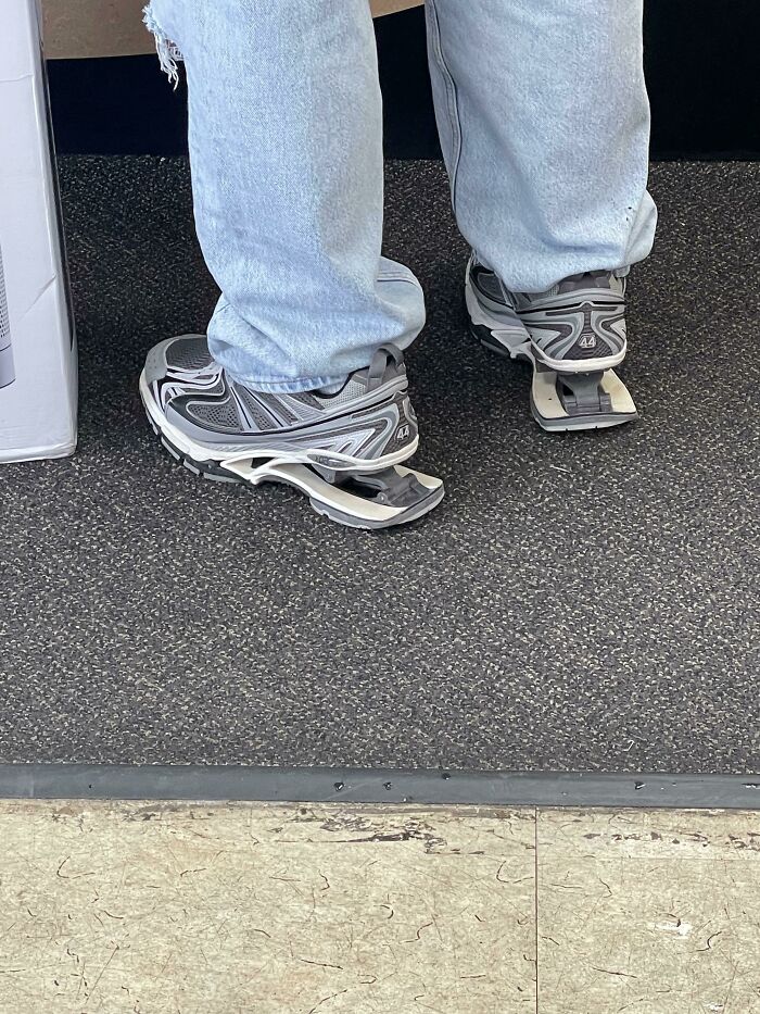 Person wearing sneakers standing on a floor with broken soles, a curious thing people discovered with no idea what they were.