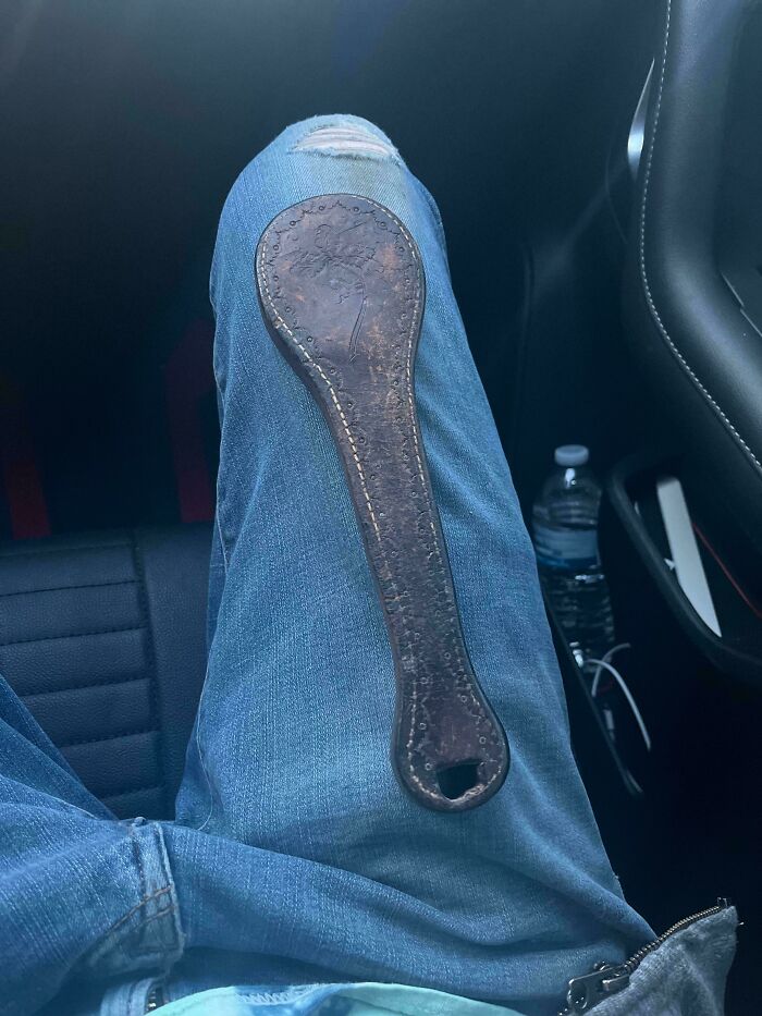 Old worn wooden tool with engraved patterns and a hole, unidentified curious thing discovered by someone.