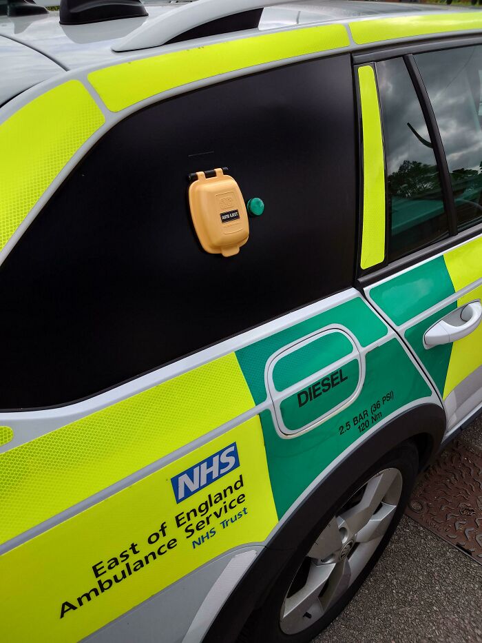 Close-up of an NHS ambulance side panel with a mysterious yellow device attached, a curious thing people discovered.