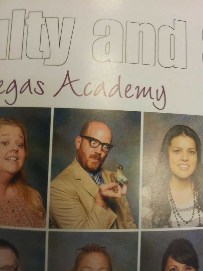 Man wearing glasses and a tan jacket holding a toy bird, showcasing funny teachers with great sense of humor in school photos.