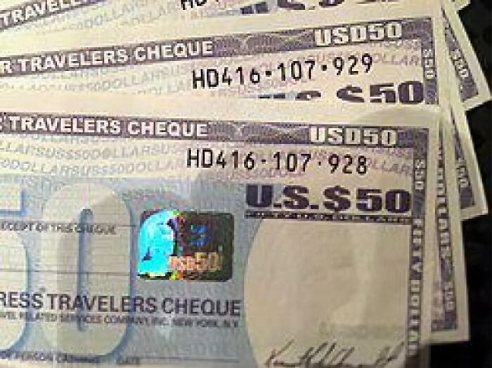 Stack of $50 travelers cheques close-up, evoking nostalgic memories and reminders of old age for many people