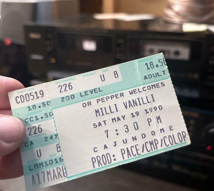 Hand holding a vintage concert ticket from 1990, evoking nostalgia and memories of old age.