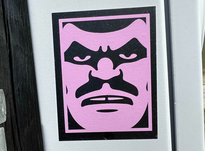 Sticker showing a mysterious purple face with black shapes, one of 46 curious things people discovered and didn't know what they were.