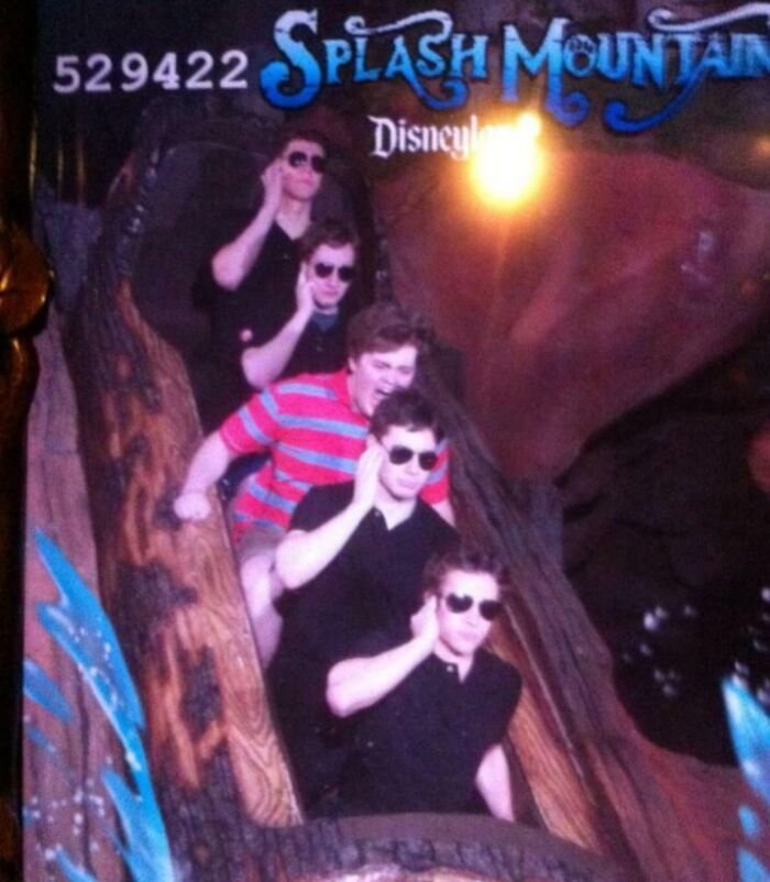 Group of friends wearing sunglasses posing humorously on Splash Mountain ride at an amusement park photo souvenir.