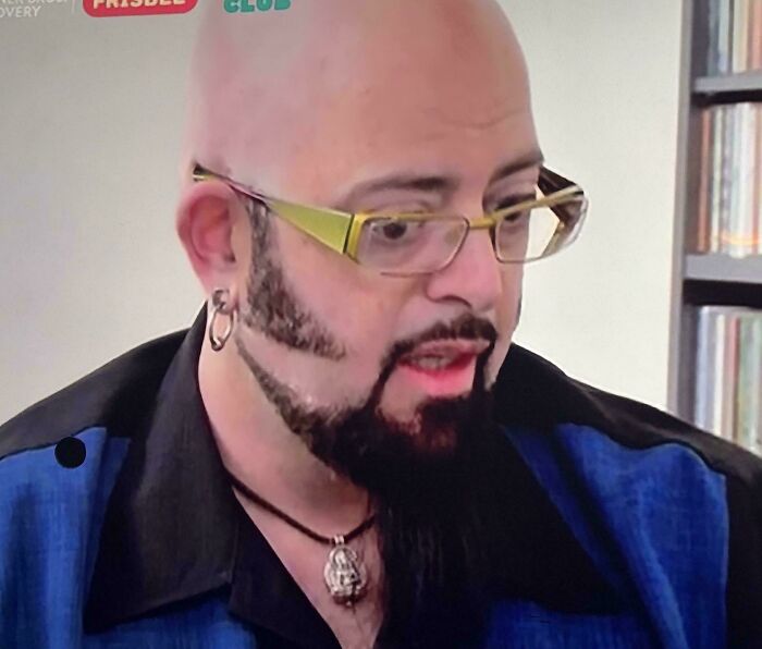 A man with a bald head, unique beard, and glasses. This is one of the unfortunate haircuts shared by the community.