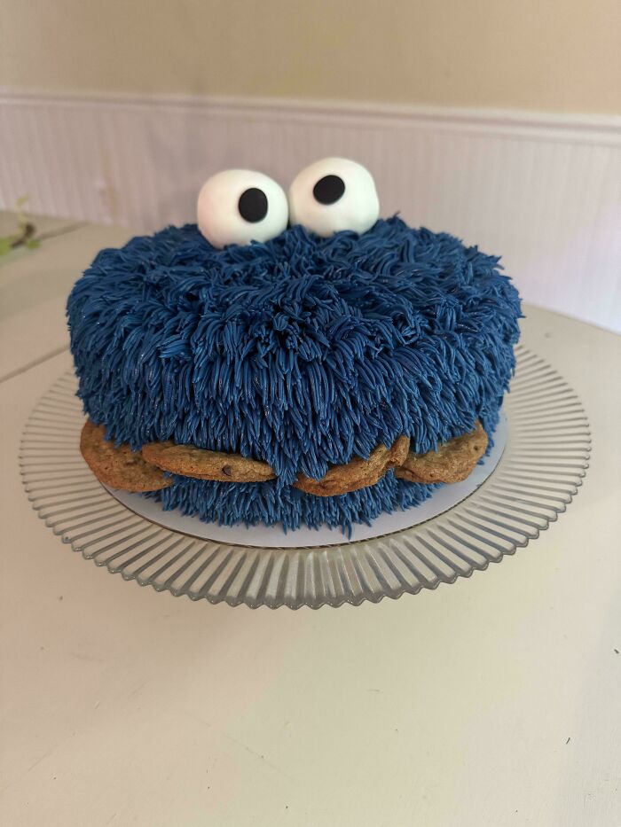 Blue furry-themed baked goods cake with large eyes and cookies, showcasing creative baked goods artistry.