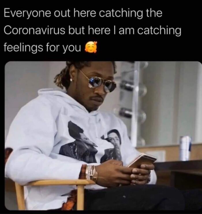 Man wearing sunglasses and a white hoodie looking at his phone with a caption about catching feelings, a cringe-worthy wholesome post.