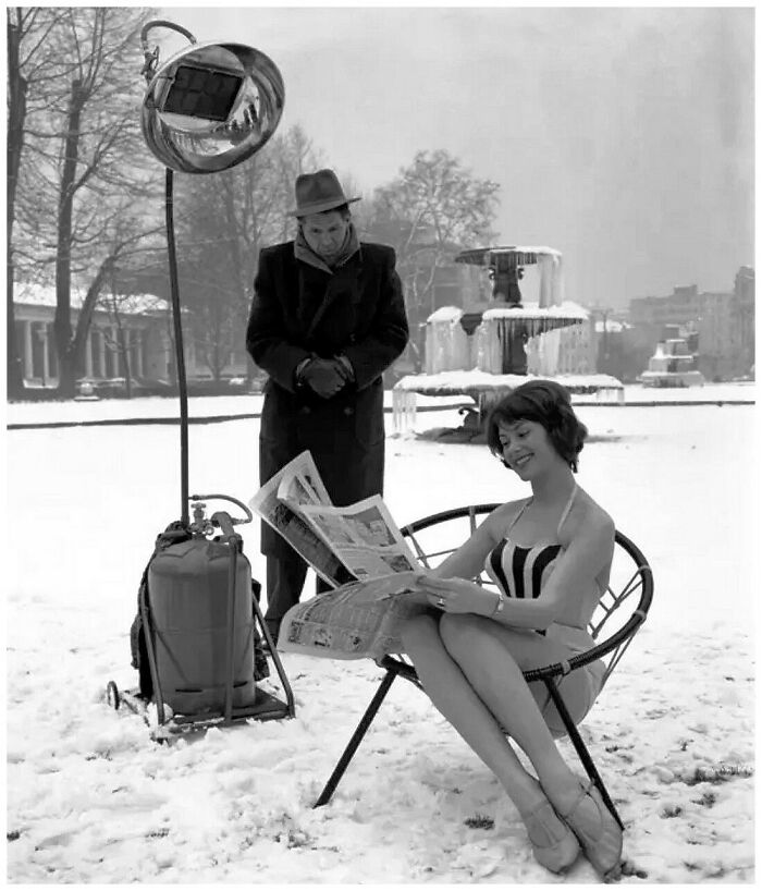 Black and white old photo showing people’s lives from a different time with a woman in a swimsuit and a man in winter clothes outdoors.