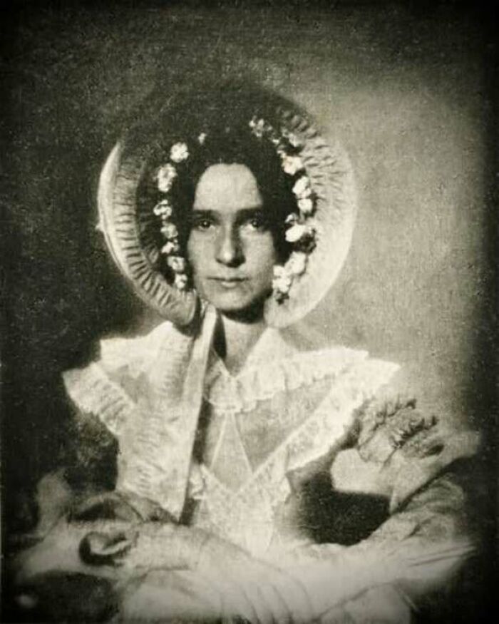 Vintage portrait of a woman in period clothing and bonnet, showcasing old photos that reveal people’s lives from a different time.