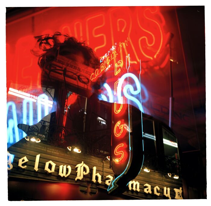 A vibrant urban scene with neon lights and reflections creating abstract aerial color photography patterns.