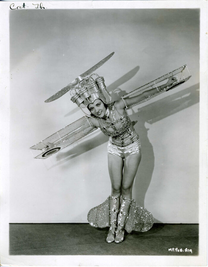 Vintage photo of a woman in a glittery airplane costume, showcasing old photos of people’s lives from a different time.