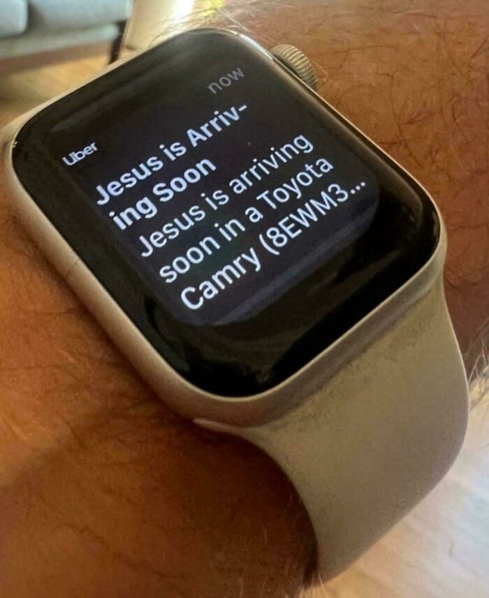 Smartwatch screen showing Uber notification stating Jesus is arriving soon in a Toyota Camry, combining holy and cursed humor.