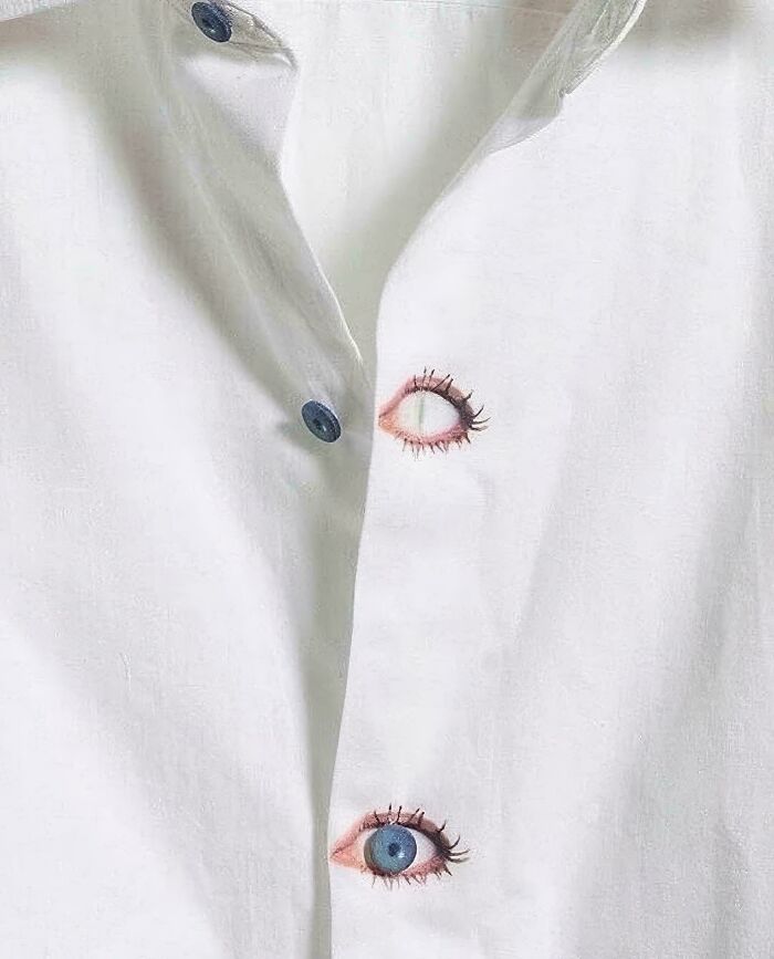 White shirt with buttons designed as realistic eyes creating a funny and bizarre image combining the holy and the cursed theme.