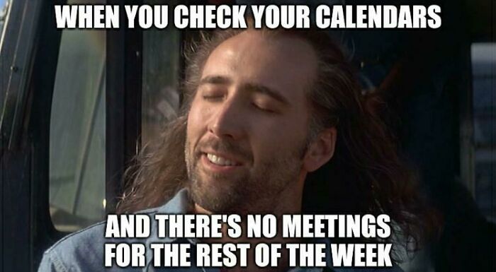 Man with long hair smiling happily in a meme about work calendars and no meetings, illustrating work memes humor.